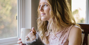 A woman who read these long distance love quotes, looking out the window and thinking of her boyfriend.