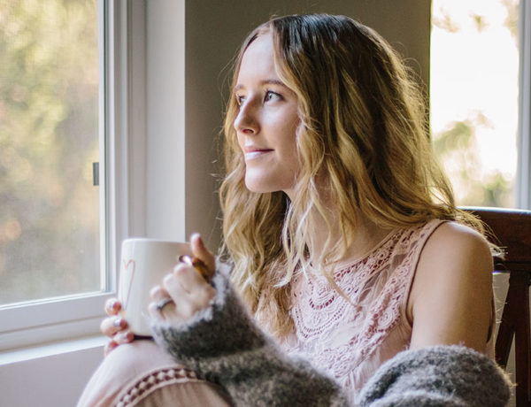 A woman who read these long distance love quotes, looking out the window and thinking of her boyfriend.