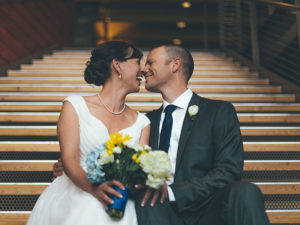 Un couple qui a appris quelque chose de ces vraies citations d'amour, assis sur les marches de l'église le jour de leur mariage, touche le nez et rigole ensemble.