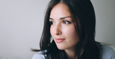 A woman who's having a hard time letting go of a relationship looking off to the distance while thinking.