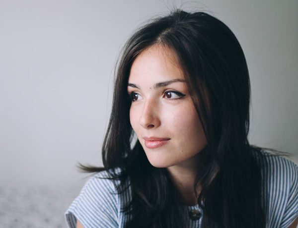 A woman who's having a hard time letting go of a relationship looking off to the distance while thinking.