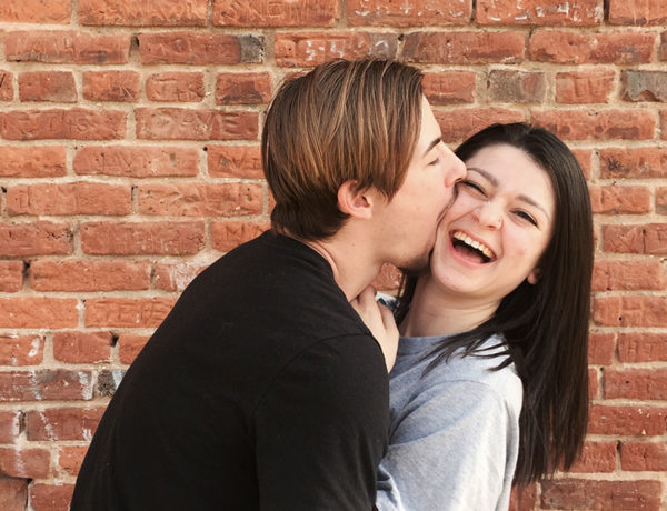 A woman laughing at her boyfriend's corny pickup lines.