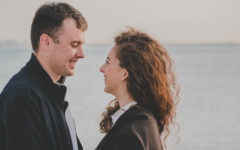 A guy using one of these flirty conversation starters looking at a woman on the beach and smiling.