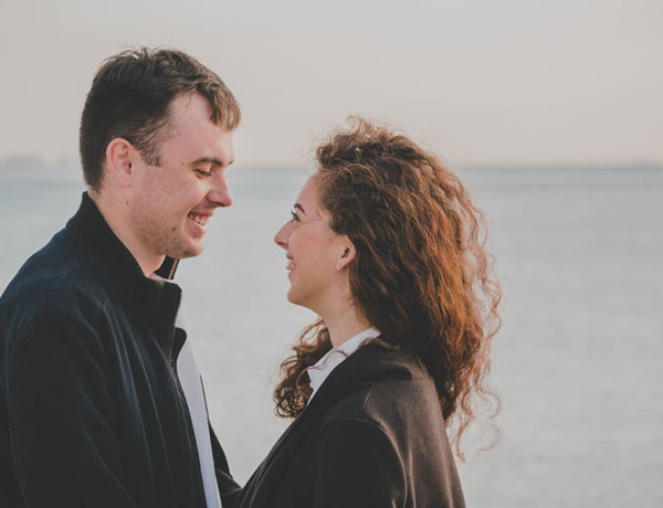 A guy using one of these flirty conversation starters looking at a woman on the beach and smiling.