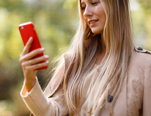 A woman reading through Tinder taglines on the app while swiping through profiles.