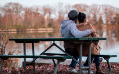 A couple sitting on a park bench.