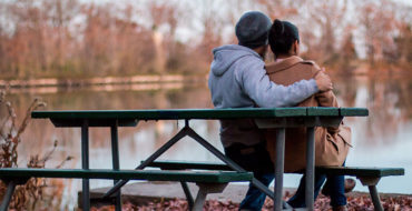 A couple sitting on a park bench.