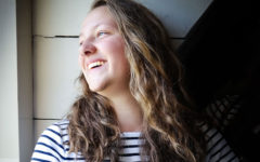 A woman laughing and looking out the window who just started dating after a breakup.