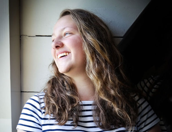 A woman laughing and looking out the window who just started dating after a breakup.