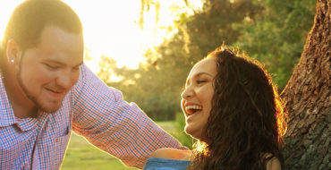 A guy showing signs he's fighting his feelings for you, leaning against a tree talking to the girl he likes trying to keep his cool.