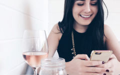 A woman laughing at her phone at one of these sweet pick up lines.