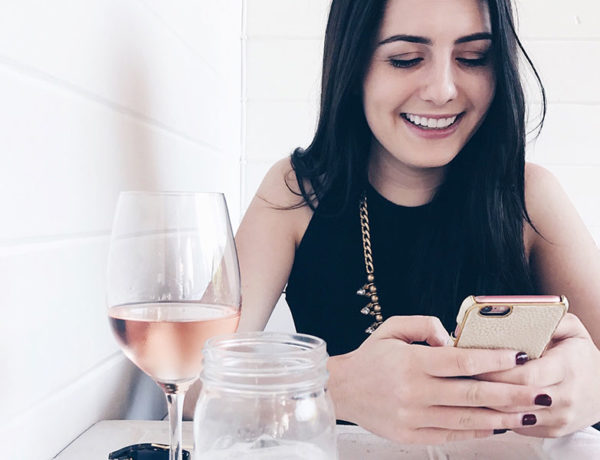 A woman laughing at her phone at one of these sweet pick up lines.