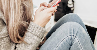 A woman texting on her phone and wondering if he texts me every day does that mean he likes me.