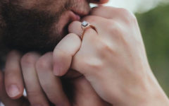 A man kissing a woman's hand and giving her a hand kiss.