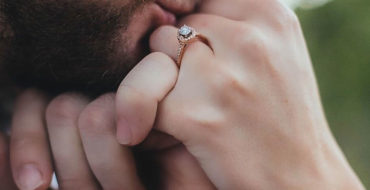 A man kissing a woman's hand and giving her a hand kiss.