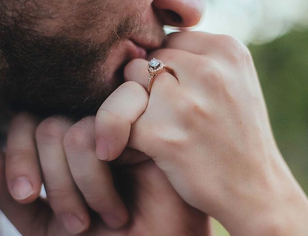 A man kissing a woman's hand and giving her a hand kiss.