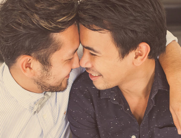 A couple in a new relationship laughing and hugging each other as they touch noses.