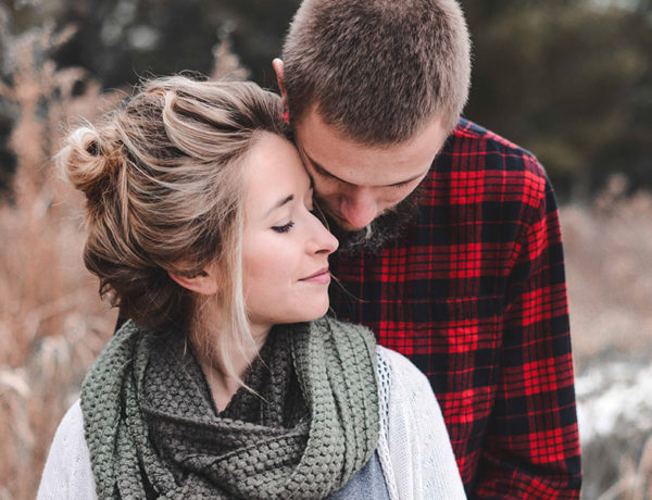A couple who shows strong emotional intimacy canoodling outside.