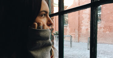 A woman looking out the window thinking about losing a friend and what she'll do next.
