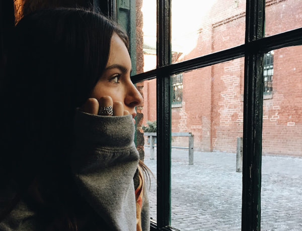 A woman looking out the window thinking about losing a friend and what she'll do next.