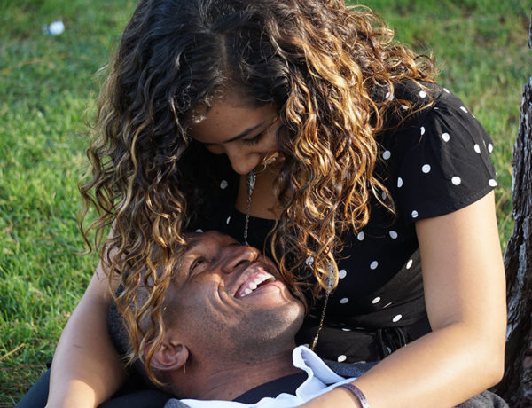 A couple talking and active listening while sitting in the grass.