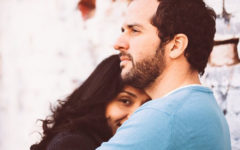 A woman who is wondering what to do when he says he loves you, hugging her boyfriend and smiling.