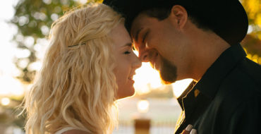 A man who wants to know who do you know when you like someone, kissing his girlfriend outside in the sun.