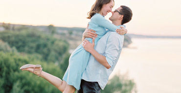 A couple who knows how to show love, laughing as they hug outside.
