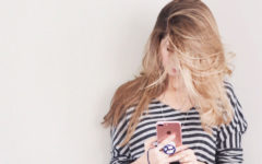 A girl who wants more matches on Tinder scrolling through profiles on her phone.