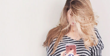 A girl who wants more matches on Tinder scrolling through profiles on her phone.