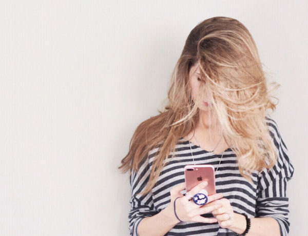 A girl who wants more matches on Tinder scrolling through profiles on her phone.