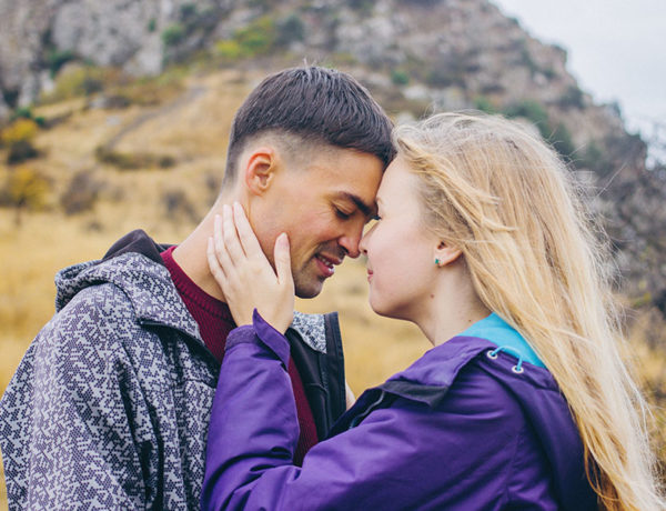 A couple who learned how to be vulnerable in a relationship leaning against each other with their eyes closed.