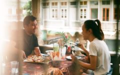 man and woman practicing good first date etiquette while eating pizza