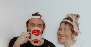 Cute couple laughing and drinking coffee while enjoying unconditional love