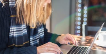 LBlonde woman typing on laptop and wondering, does online dating work?
